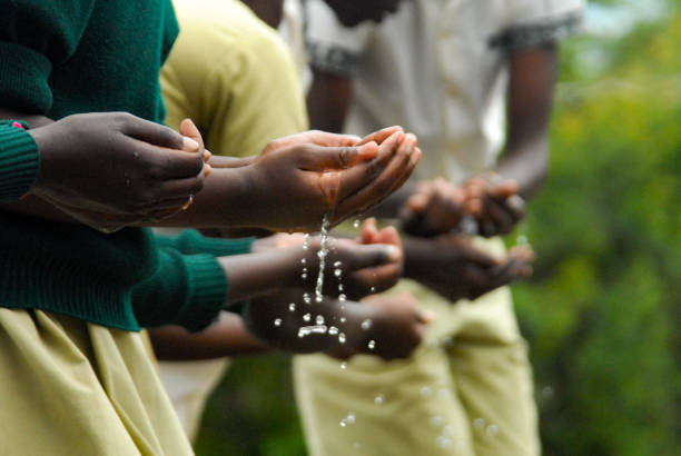 African kids passing water game from hand to hand selective focus Kenya